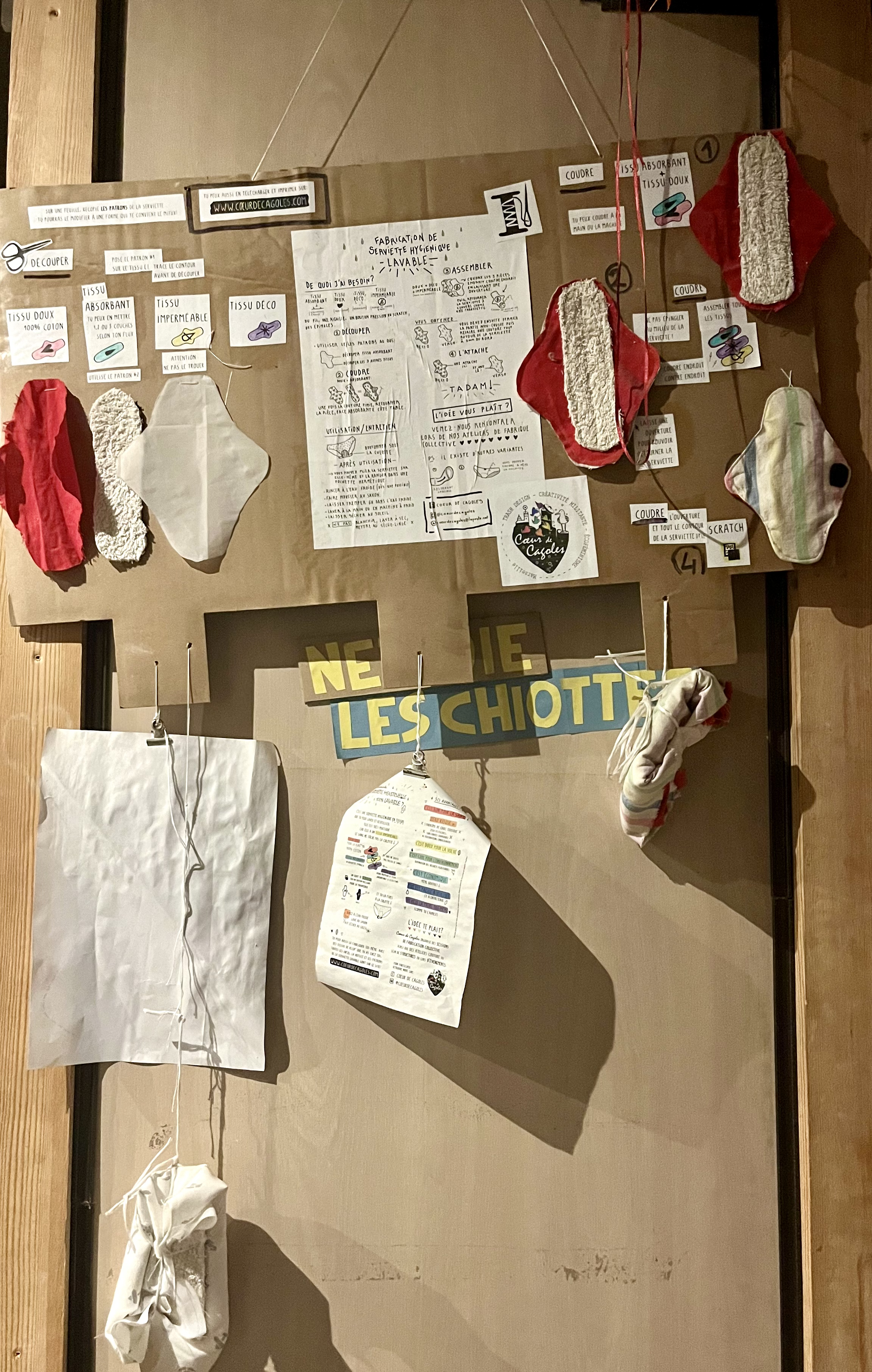 Along the walls, sanitary pads patterns are displayed on a large board. Photo: Clara Gazel