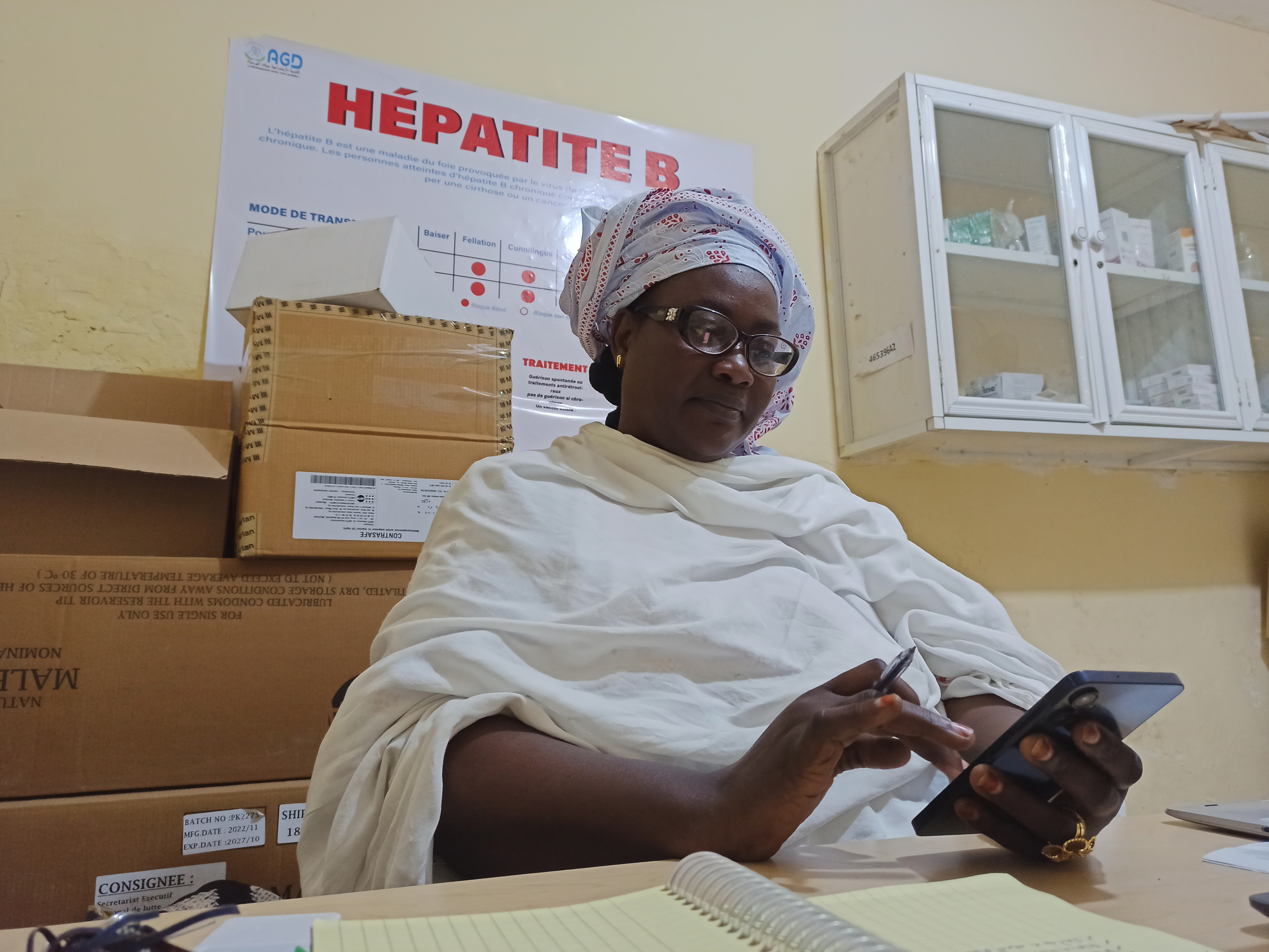 A son bureau, Haoussa Mamadou Ndiaye discute par texto avec un de ses patients